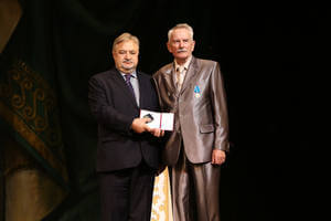 Пётр Костенич награждает нагрудным знаком Германа Русанова