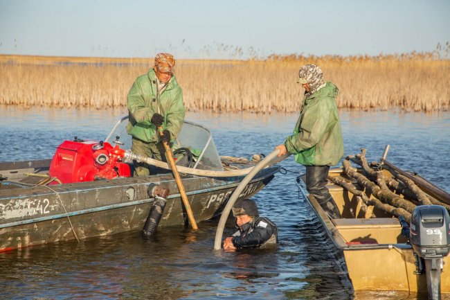 Размывают в дне мотопомпой лунку для установки граничного знака. Фото Кашина Алексея